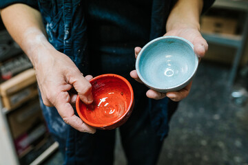 Crop artisan showing colorful ceramic bowls