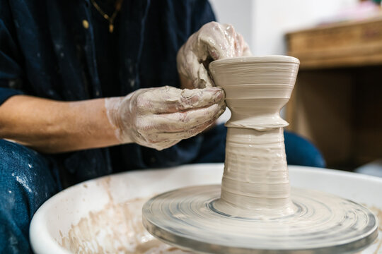 Crop master working with wet ceramic on wheel