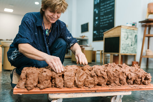 Smiling woman with clay on tray