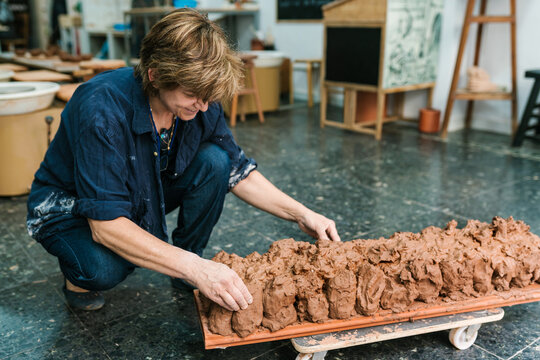 Ceramist arranging the raw clay in the workshop