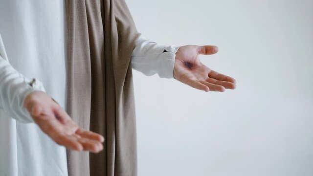 Jesus' hands with stigmata on a white background. Studio. High quality 4k footage