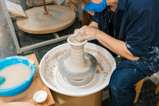 anonymous potter's hands on the potter's wheel