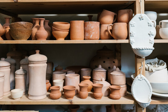 Uncolored ceramic pieces on shelves