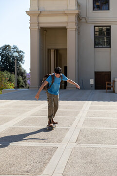 Young Man Skateboarding on Campus