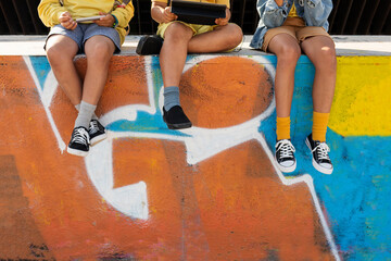 Children's legs hanging on a wall with graffiti