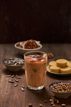 Ice milk coffee on wood background with nuts and snack.
