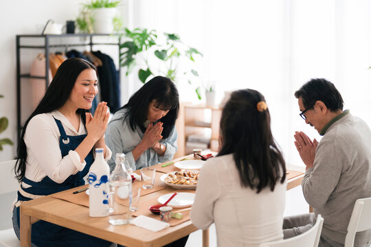 Japanese friends praying together before lunch