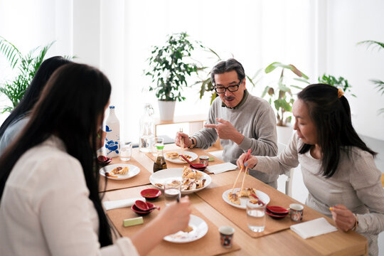 Group of Asian friends eating gyoza during lunch