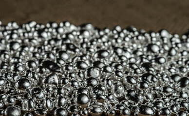 Pure silver granule texture. Background from silver pellets. Selective focus.