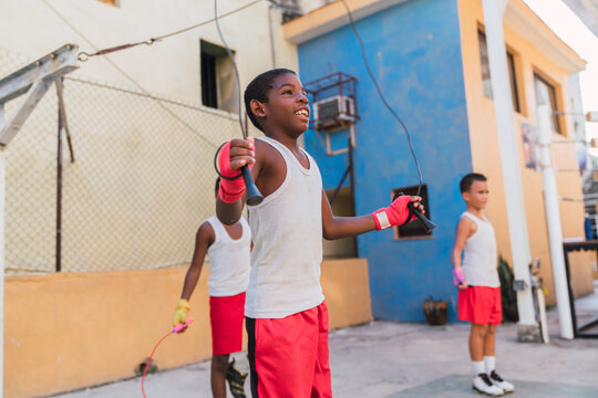 Teens in sportswear jumping with skip ropes