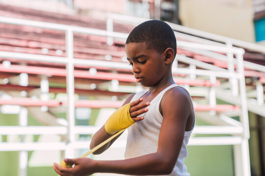 Young kid putting bandages on hands.