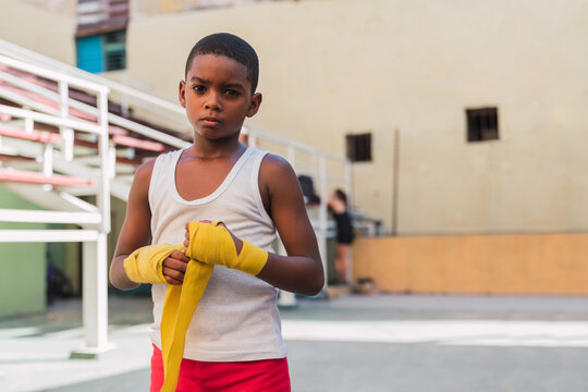 Young kid putting bandages on hands.