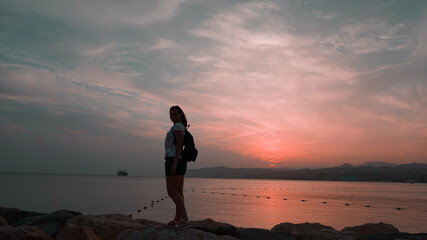 silhouette of a girl against the background of a sunset on the sea