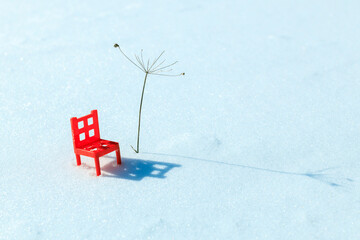 there is a chair in the snow next to a makeshift palm tree. winter resort in winter