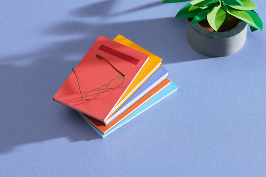 Heap of books and glasses on table in class