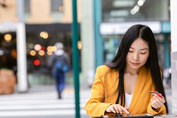 Young Chinese woman making online order on street