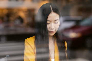 Pretty young woman behind glass