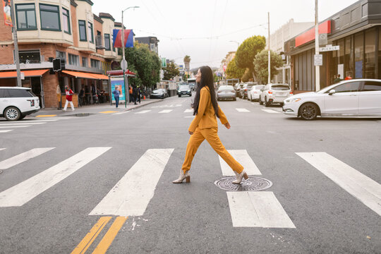 Young woman crossing road in city