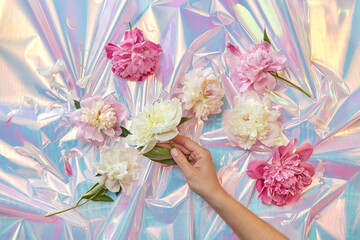 Woman touching peonies at holographic foil