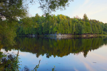 Fototapeta na wymiar calm river with trees and rock reflections natural forest environment East Angus Quebec