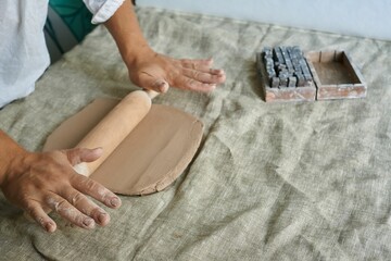 master craftsman rolls clay on the table
