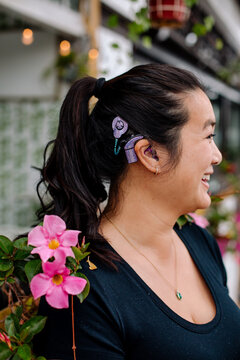 Laughing Asian woman with cochlear implant 
