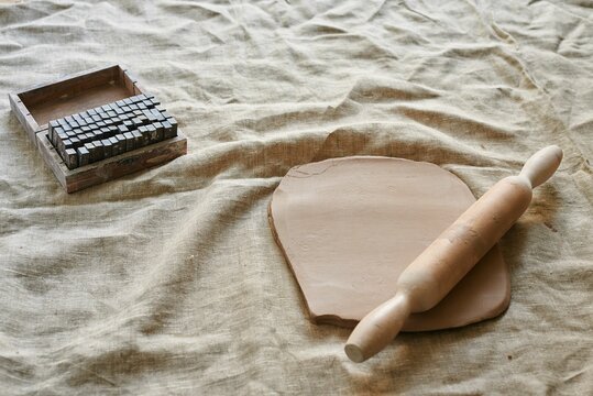 rolled clay with a wooden rolling pin on the table - Powered by Adobe