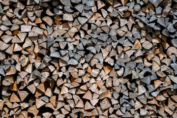 Background of dry chopped firewood logs in a pile