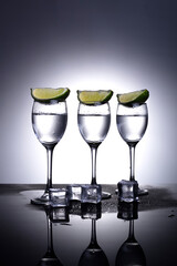 glasses with vodka on a white and gray background with lime