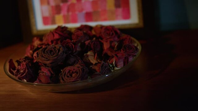 Beautiful plate with dried rose petals standing on table. Dish with dry flowers