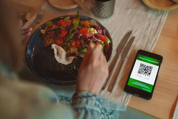 Smartphone app with certificate of immunization in restaurant. Status is valid.