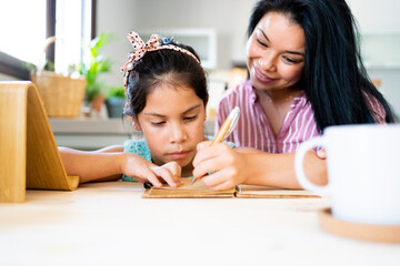Latin mother helping her daughter do homework