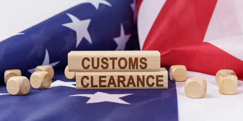 The American flag has wooden cubes and plaques that say - CUSTOMS CLEARANCE