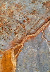 Dry rusty river bed over grey mine tailings, acid mine drainage vertical texture 