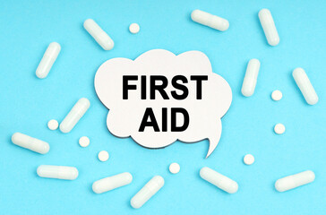 On a blue background pills and a plate. Inside the sign it says - FIRST AID