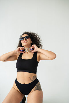 Cocky Hispanic female in underwear with curly hair