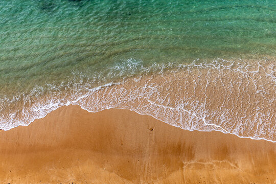 Aerial View of a sandy beach with turquoise ocean waves
