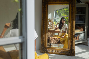 Indian Chinese bohemian woman looking at the mirror
