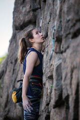 A girl climbs a rock