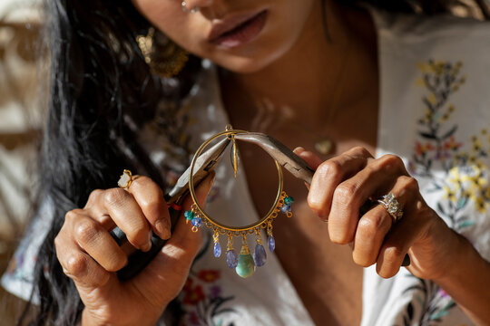 Indian Chinese woman working on her Jewellery close up