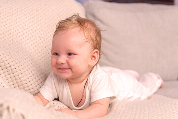 Cute smiling baby on a beige sofa. happy childhood