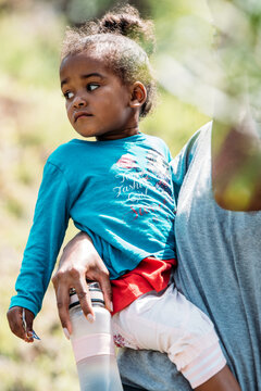 crop african woman holding little girl