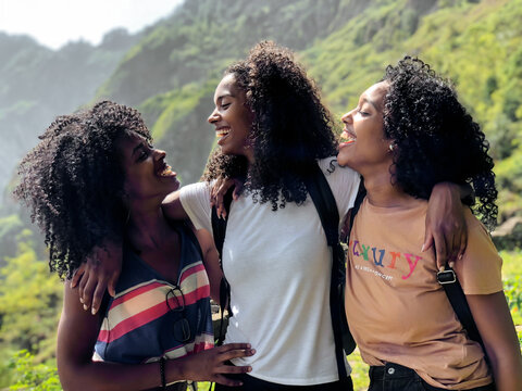 black ethnic afro sisters looking at camera while hiking