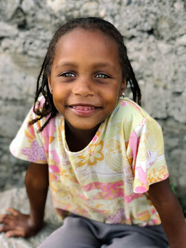 Cute little african girl with green eyes looking at camera