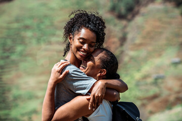 Black mother and daughter outdoors hugging and looking at each other with love in Cape verde Africa