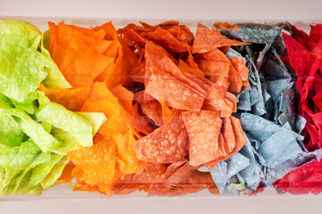 colors of crackers. chips in a tube, chips in a glass container, different types of  snacks. Concept unhealthy food.