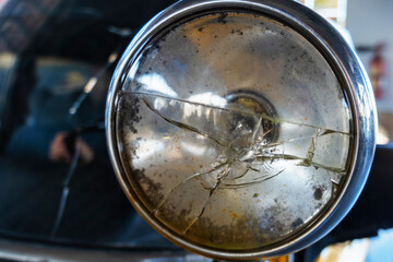 Obraz na płótnie Canvas Broken car headlamp. Damaged automobile headlight. The automotive light is broken.
