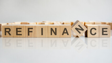 word refinance on wooden cubes, gray background