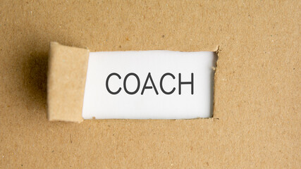 the text coach behind torn brown paper