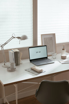 Desk with laptop and stationery in light workspace